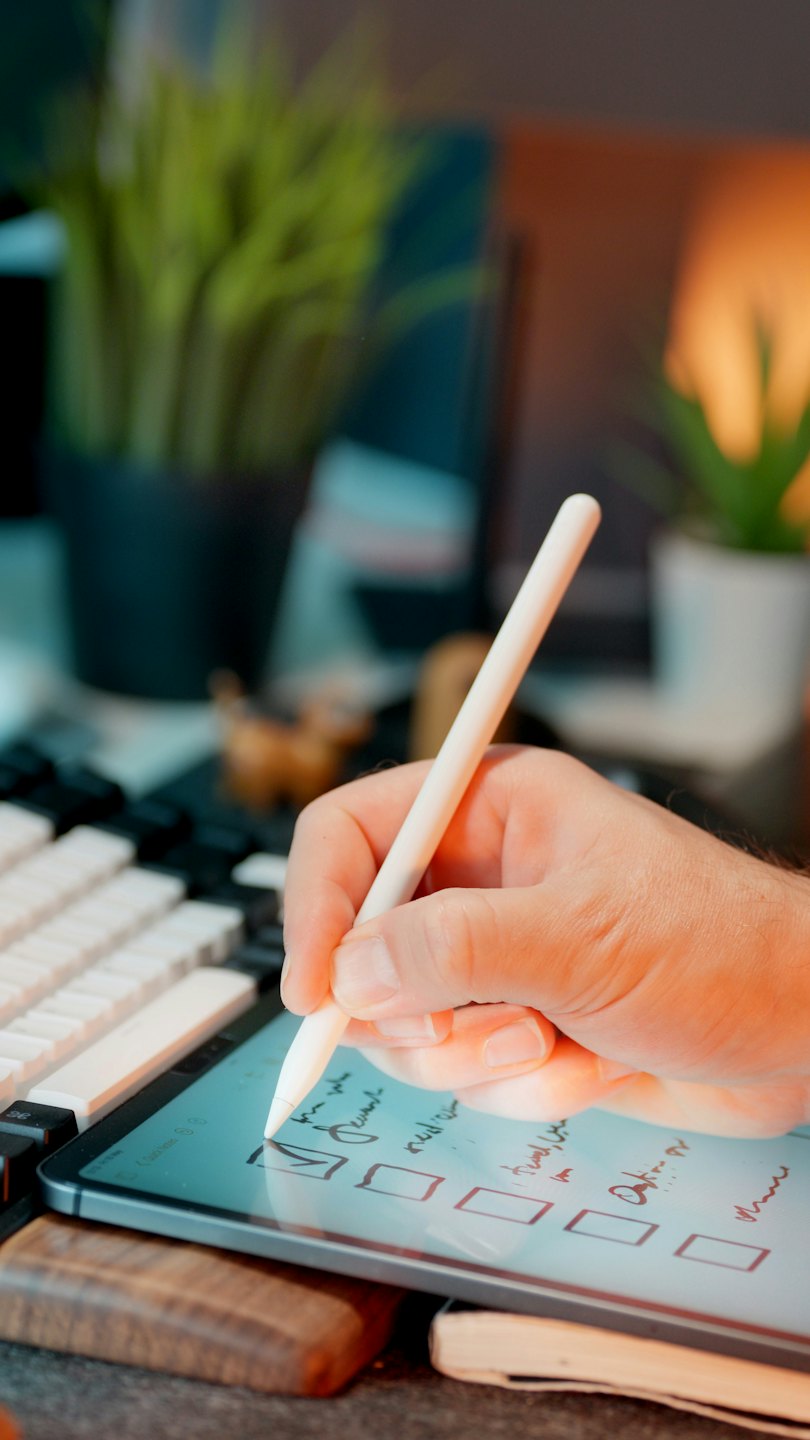 En hand använder en stylus för att bocka av en digital att göra-lista.